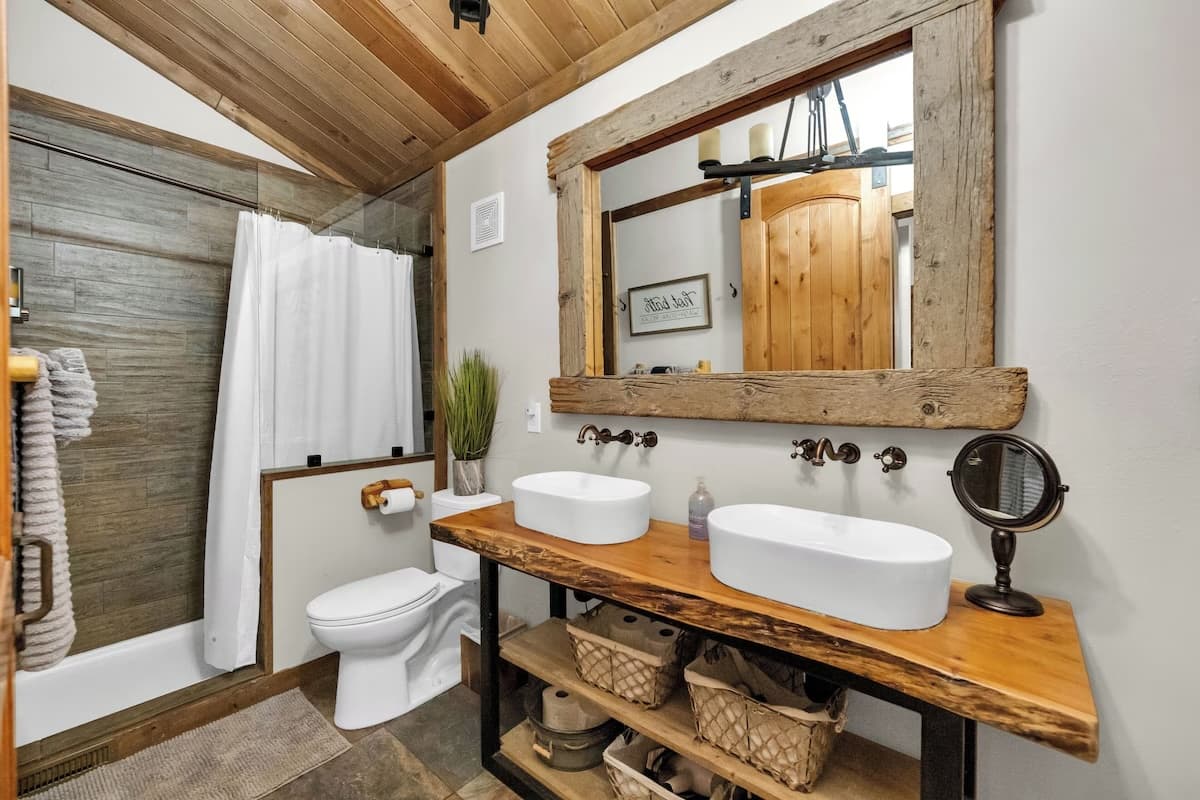 Bathroom with double vessel sinks and rustic wood mirror